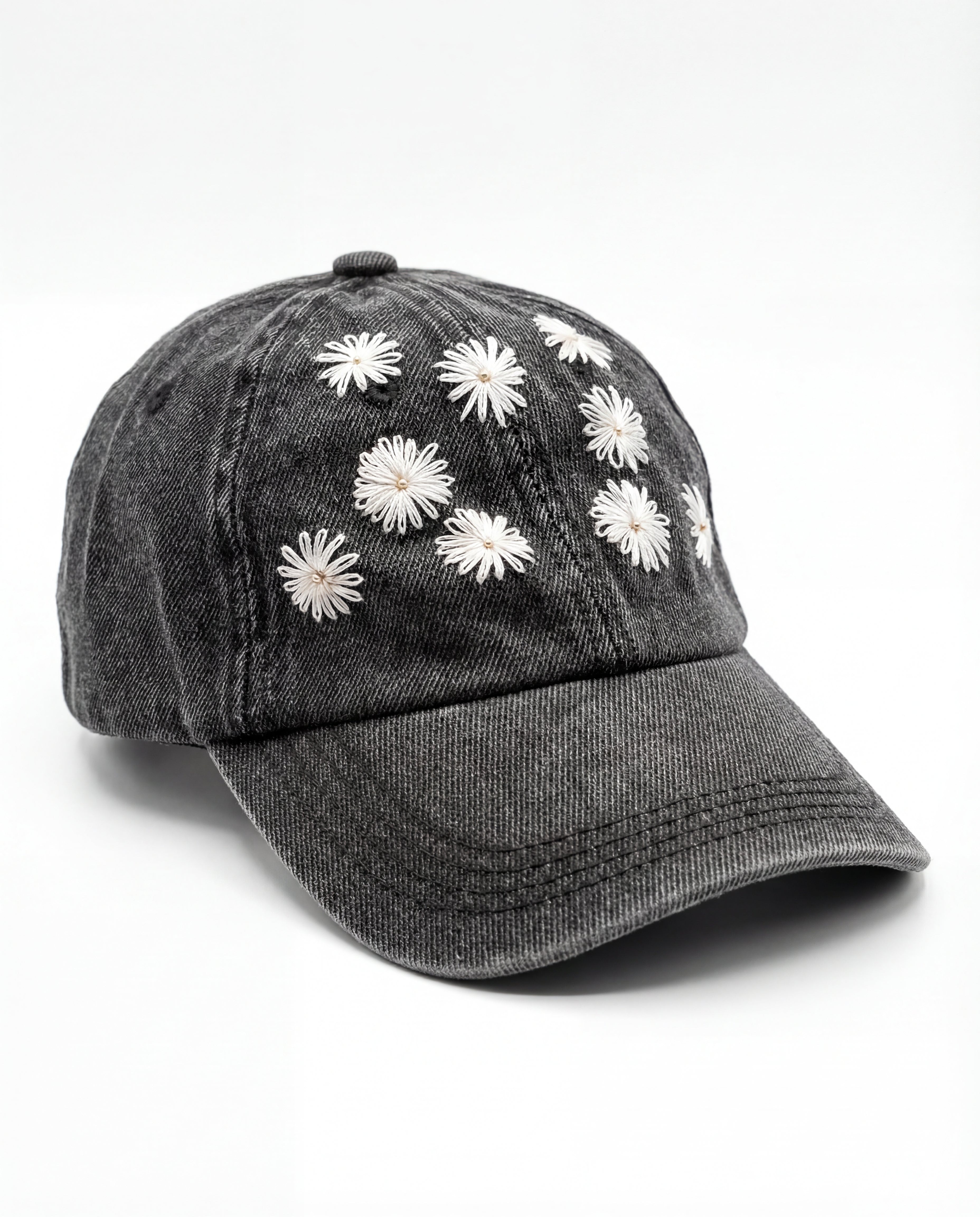 Black denim cap with white floral embroidery on a white background