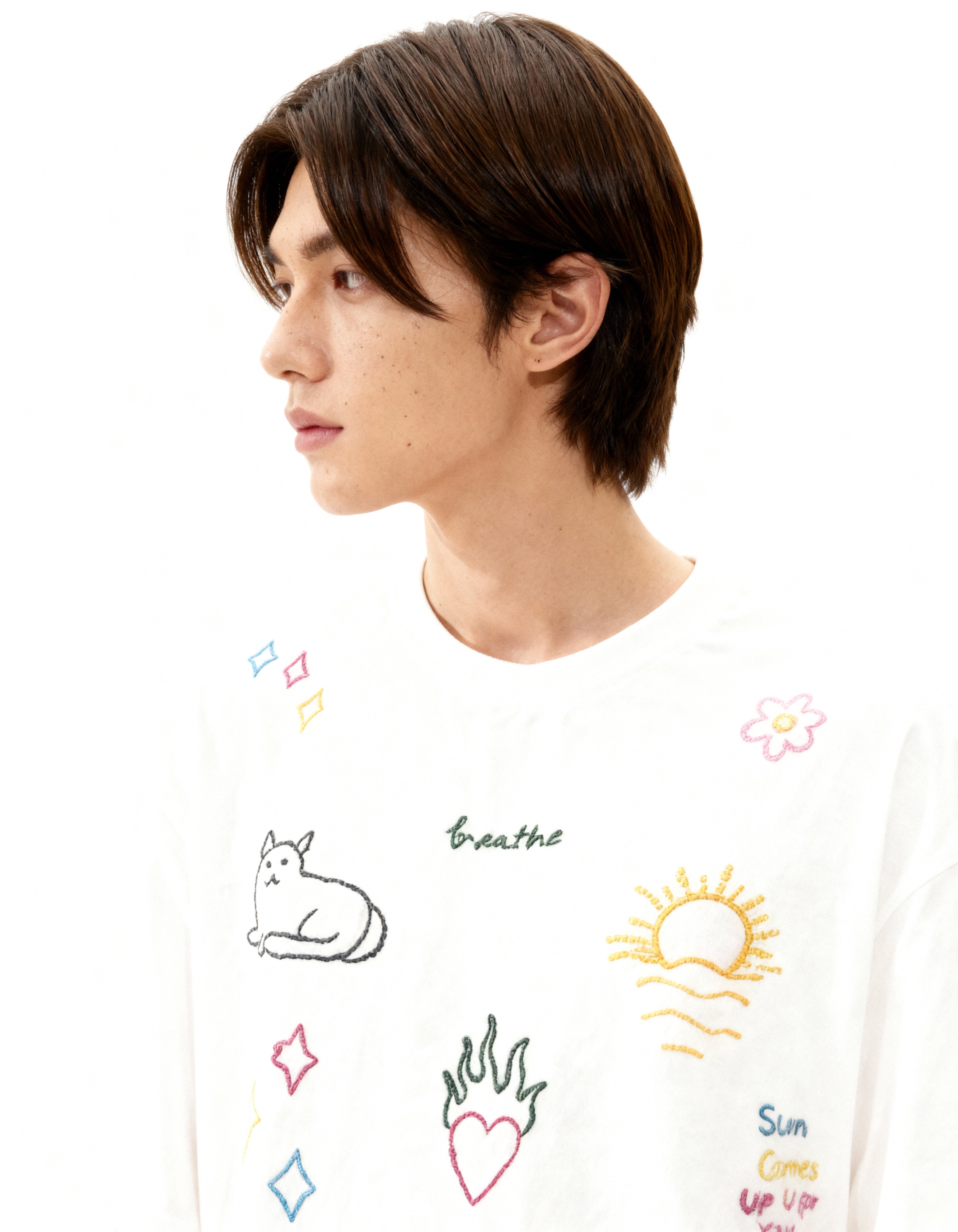 Person wearing a white shirt with colorful graphics and text