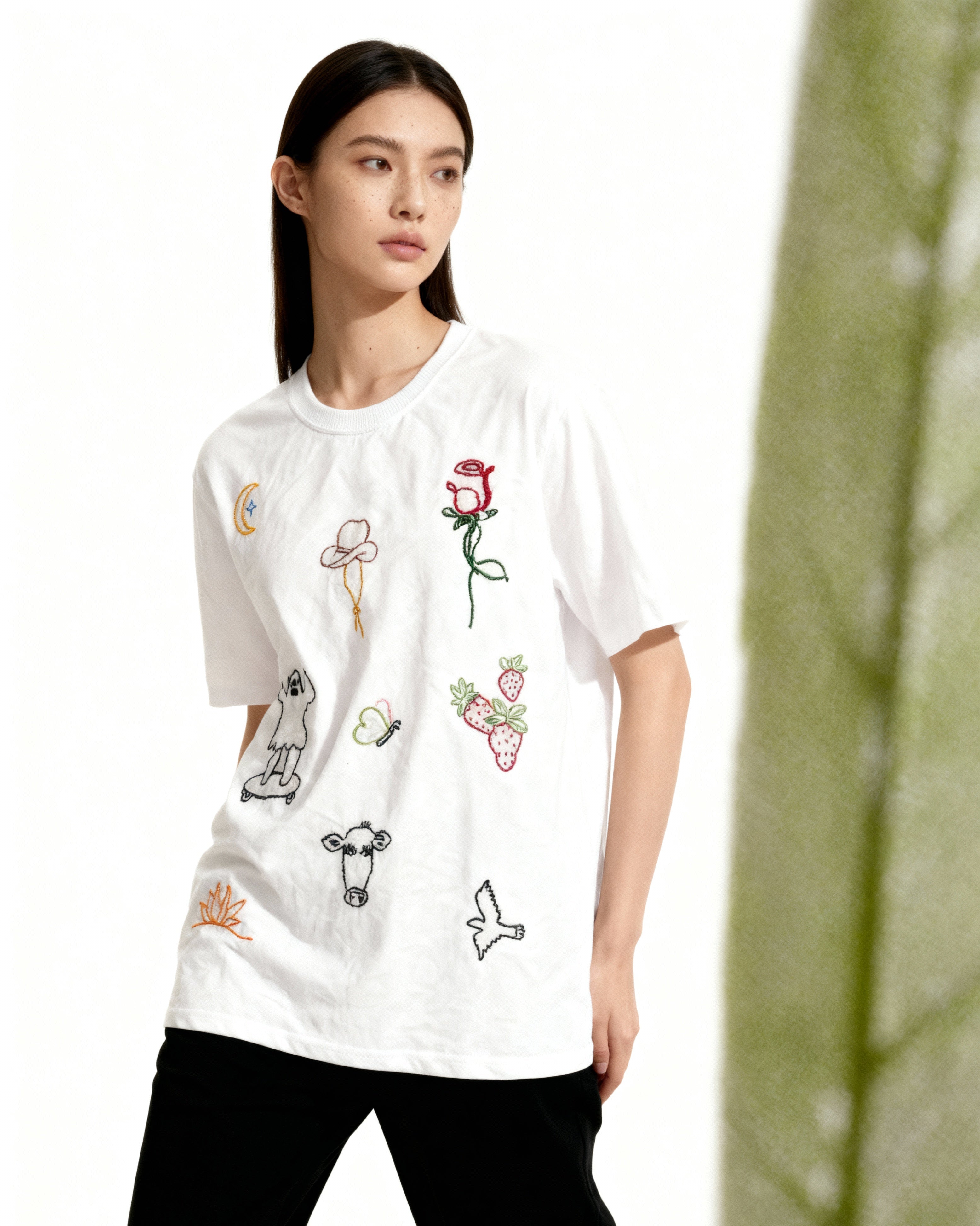 Woman wearing a white t-shirt with colorful graphics on a white background