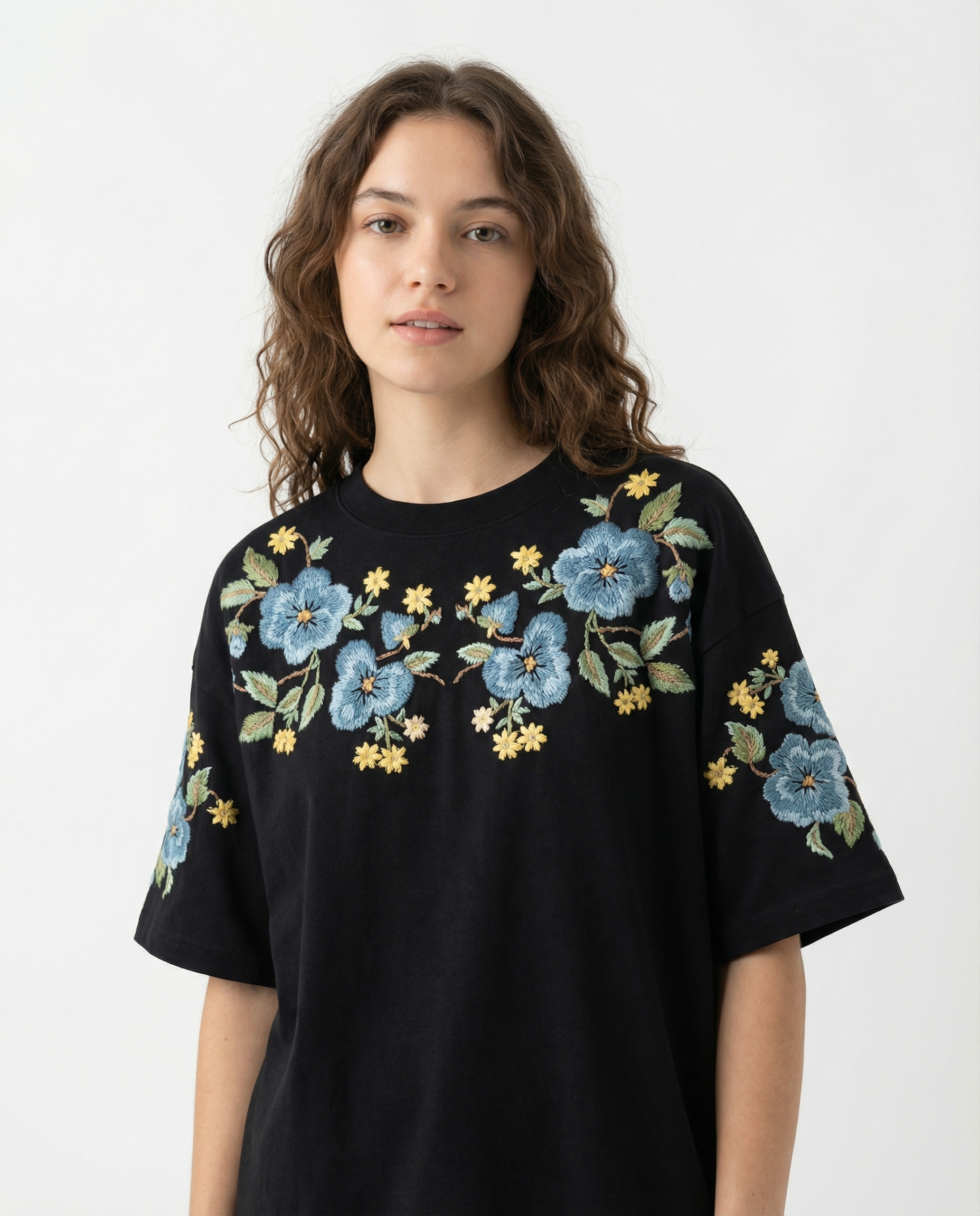 Woman wearing a black t-shirt with floral embroidery on a white background