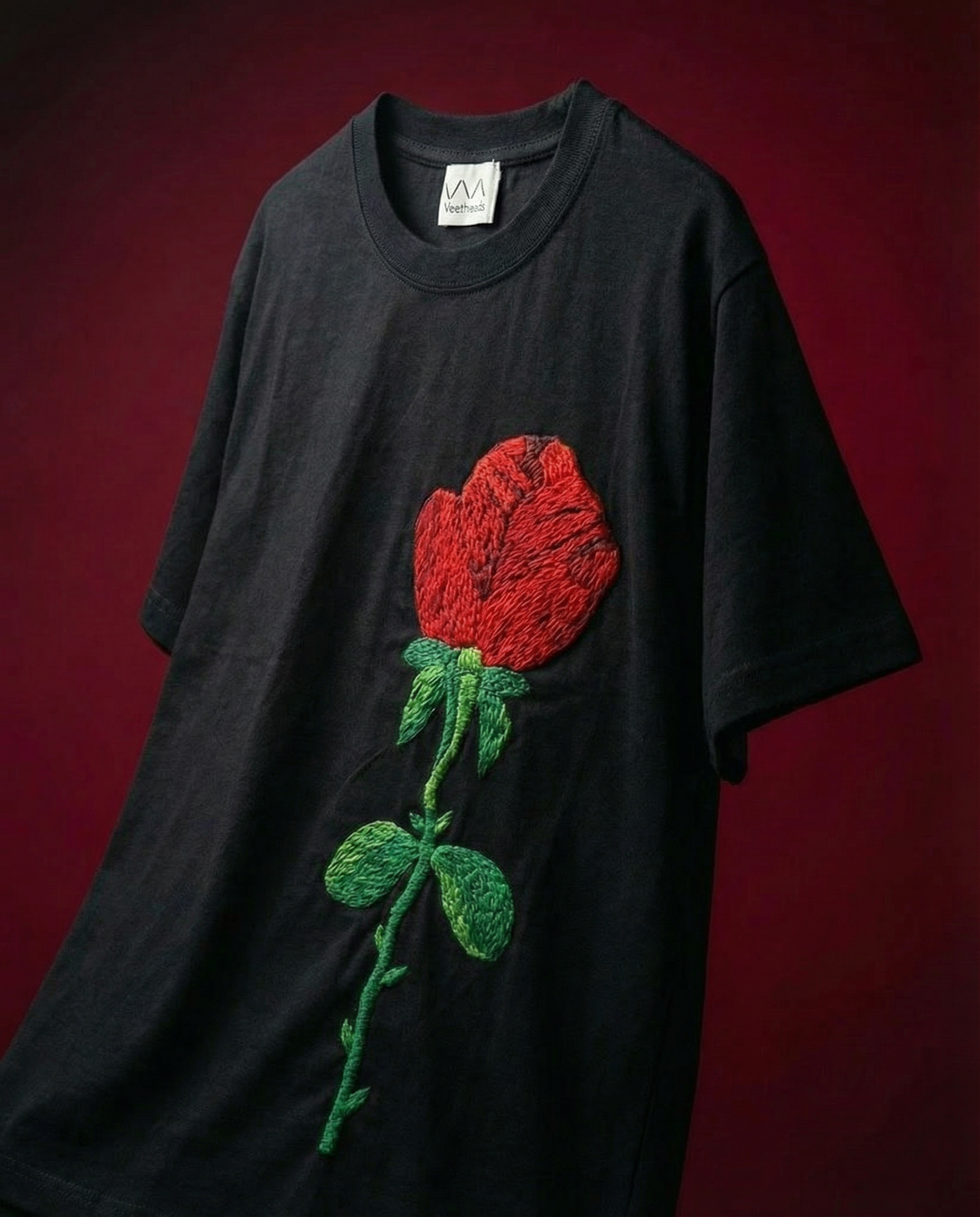 Black t-shirt with a red rose design embroidered on a dark background