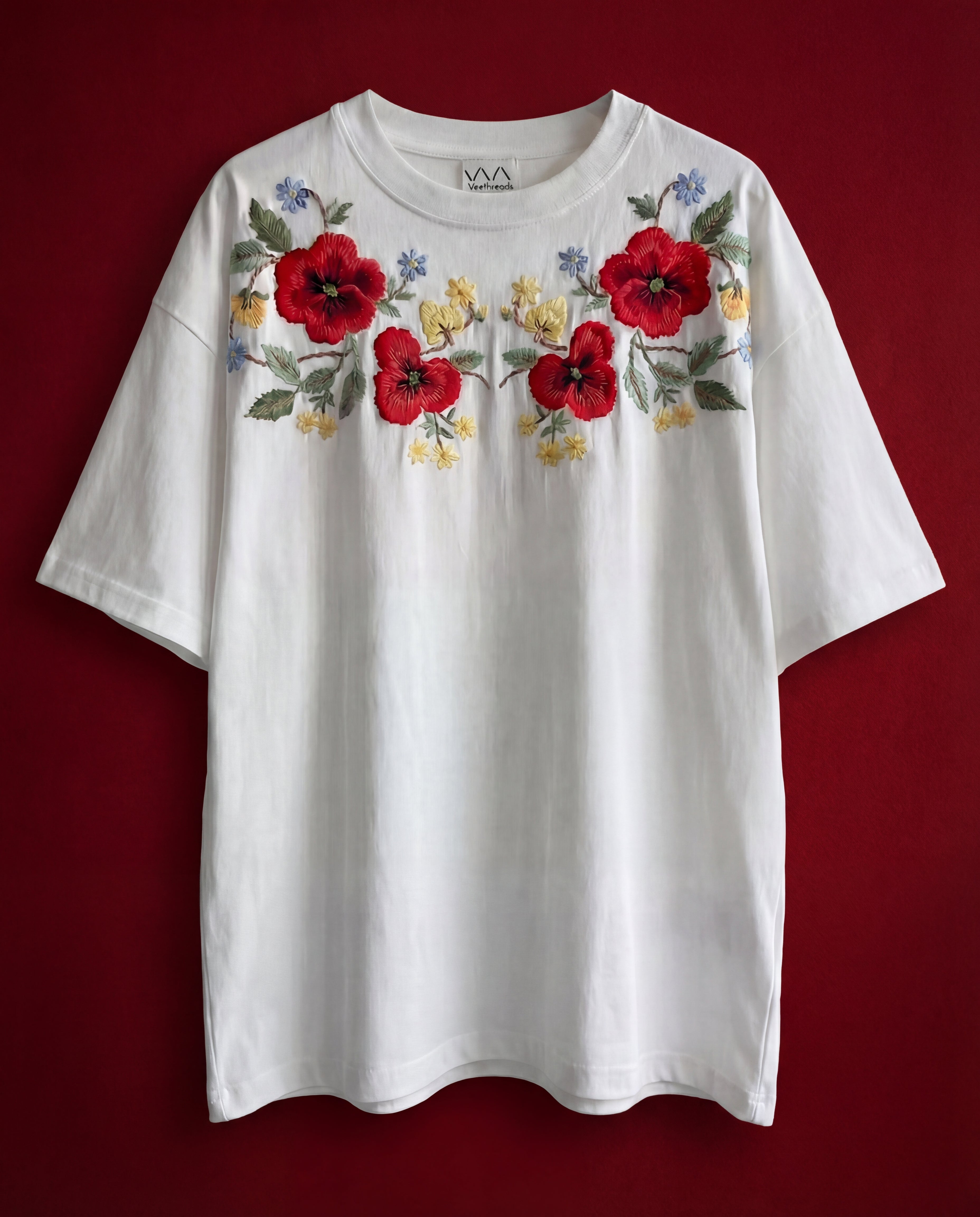 Vintage-style red floral embroidery on a 220 GSM cotton oversized tee — raised real-thread stitching, hand-made by Vee Threads artisans.