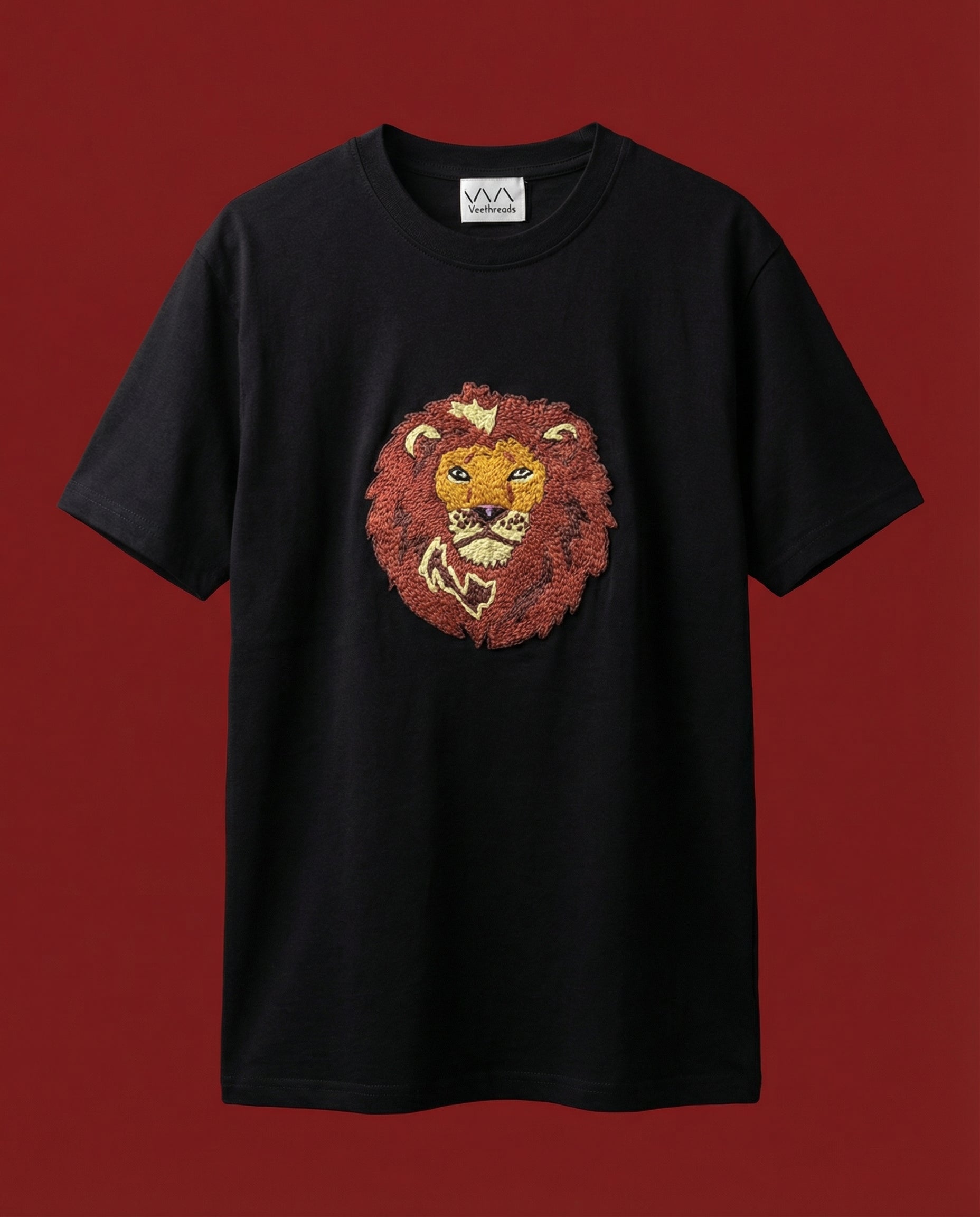 Black t-shirt with a lion embroidered  on a red background