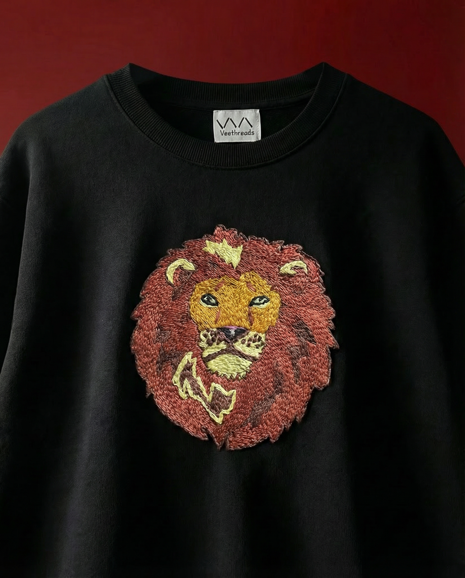 Lion hand-embroidered on a black 240 GSM cotton oversized tee — bold lion face in real thread, oversized unisex fit.
