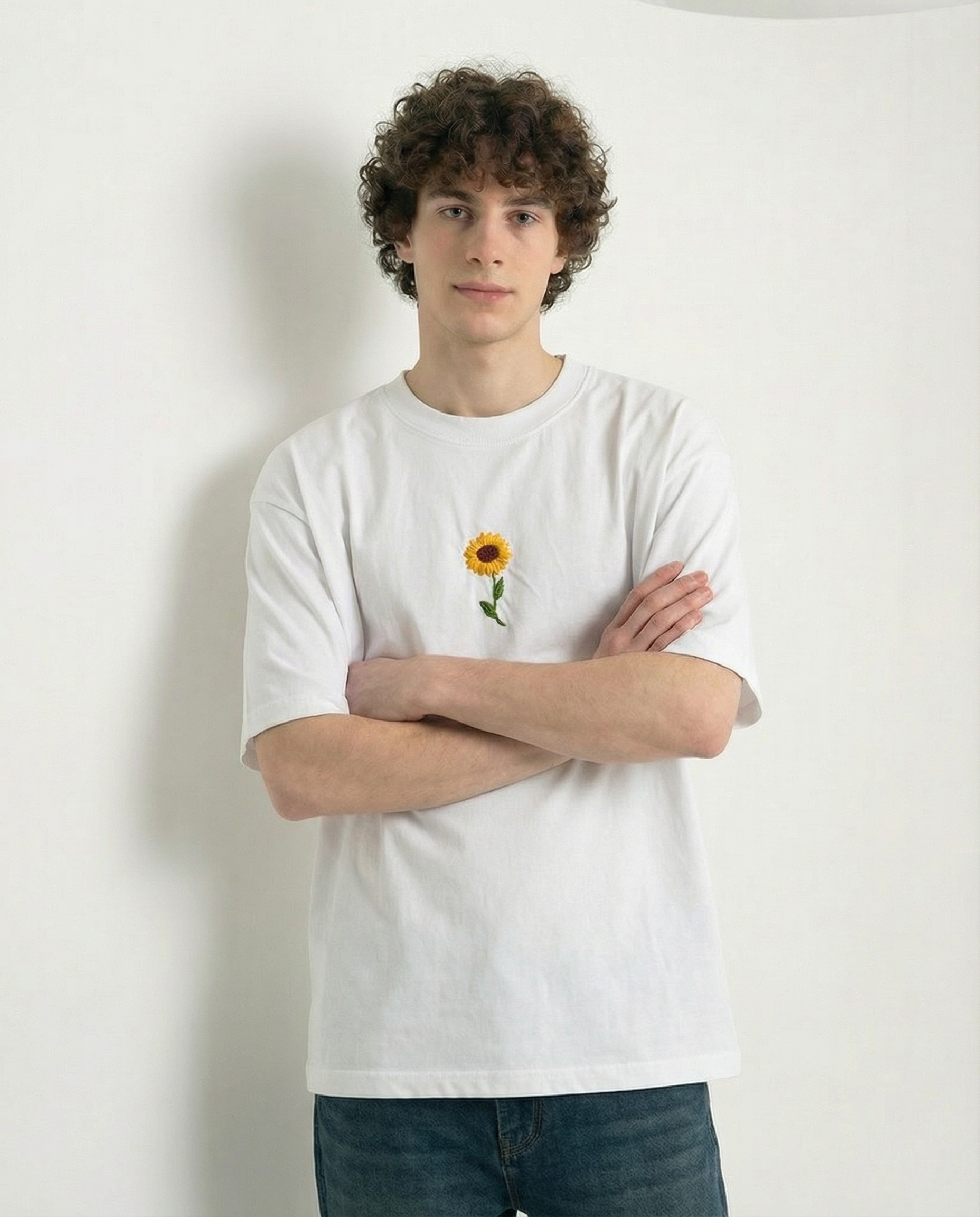 Person wearing a white t-shirt with a sunflower design against a plain background