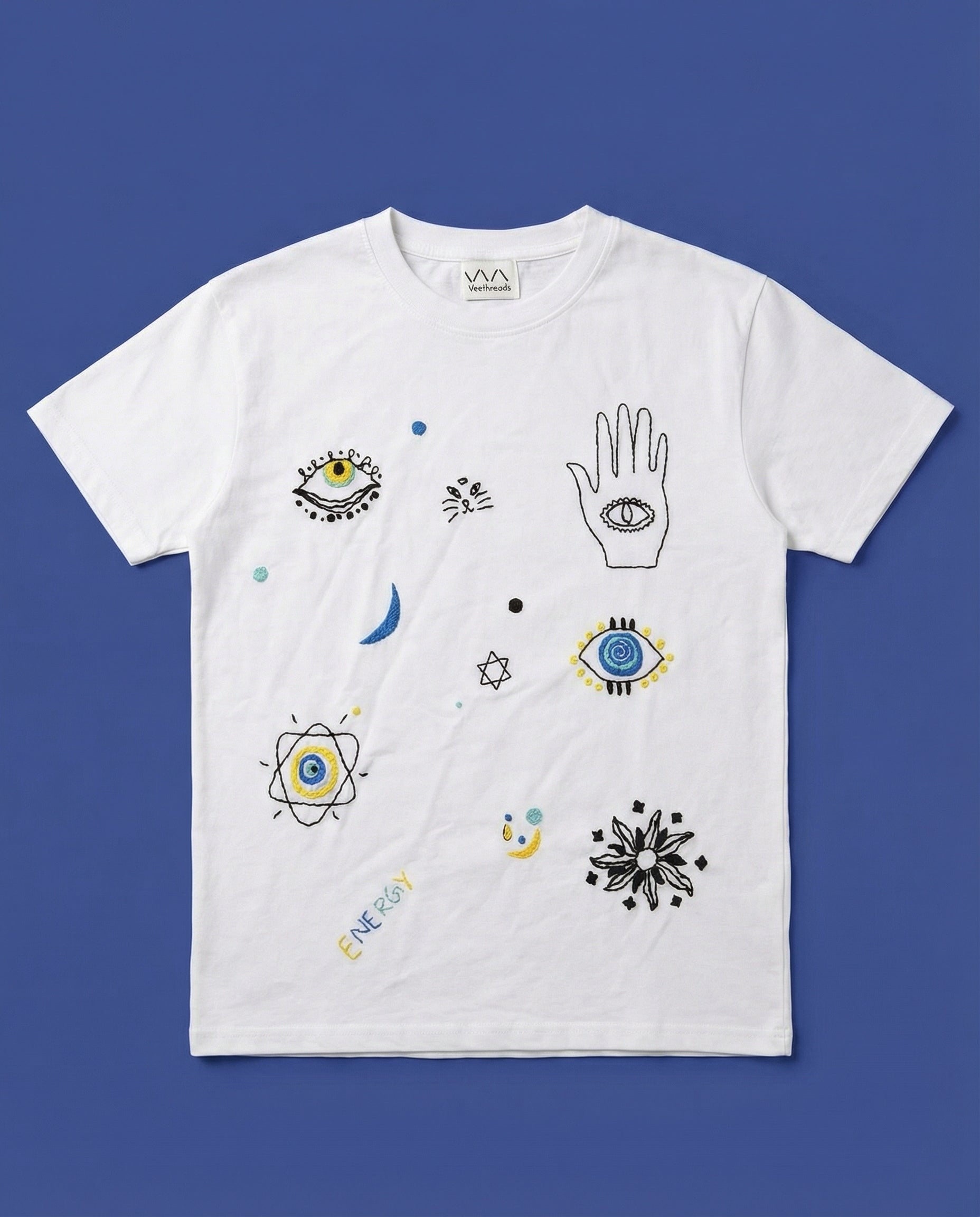 White t-shirt with various doodles style embroidery on a blue background
