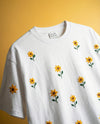 White t-shirt with sunflower floral embroidery on a yellow background