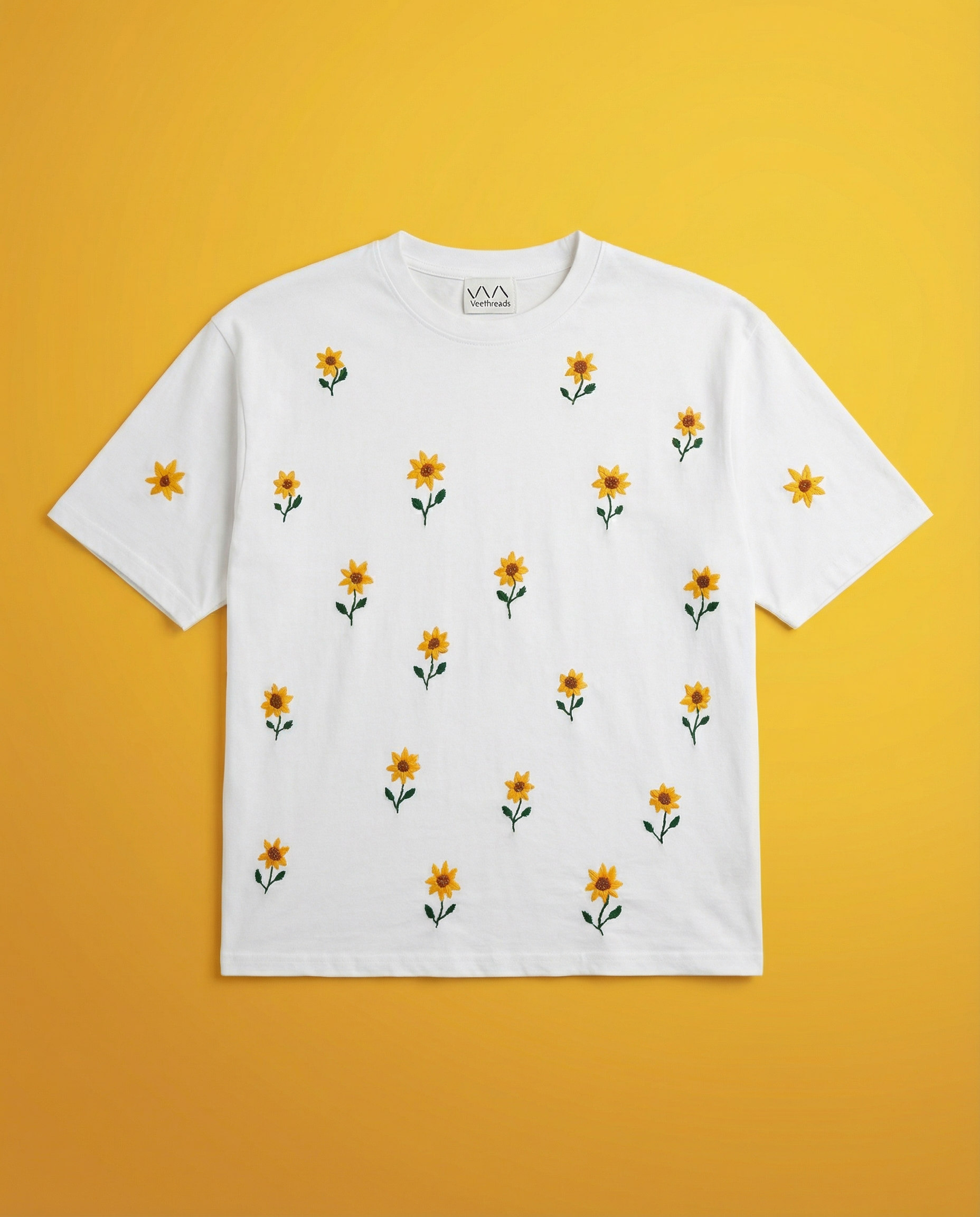 White t-shirt with small yellow sunflower patterns on a yellow background