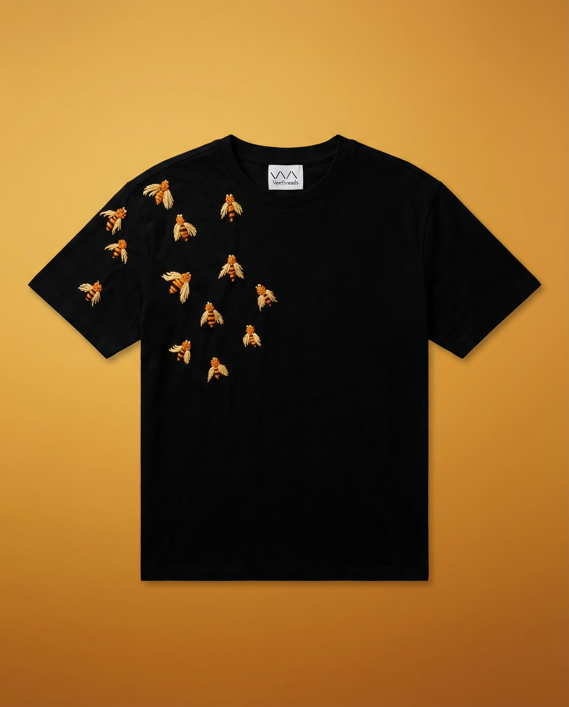 Black t-shirt with hand embroidered designs on a yellow background