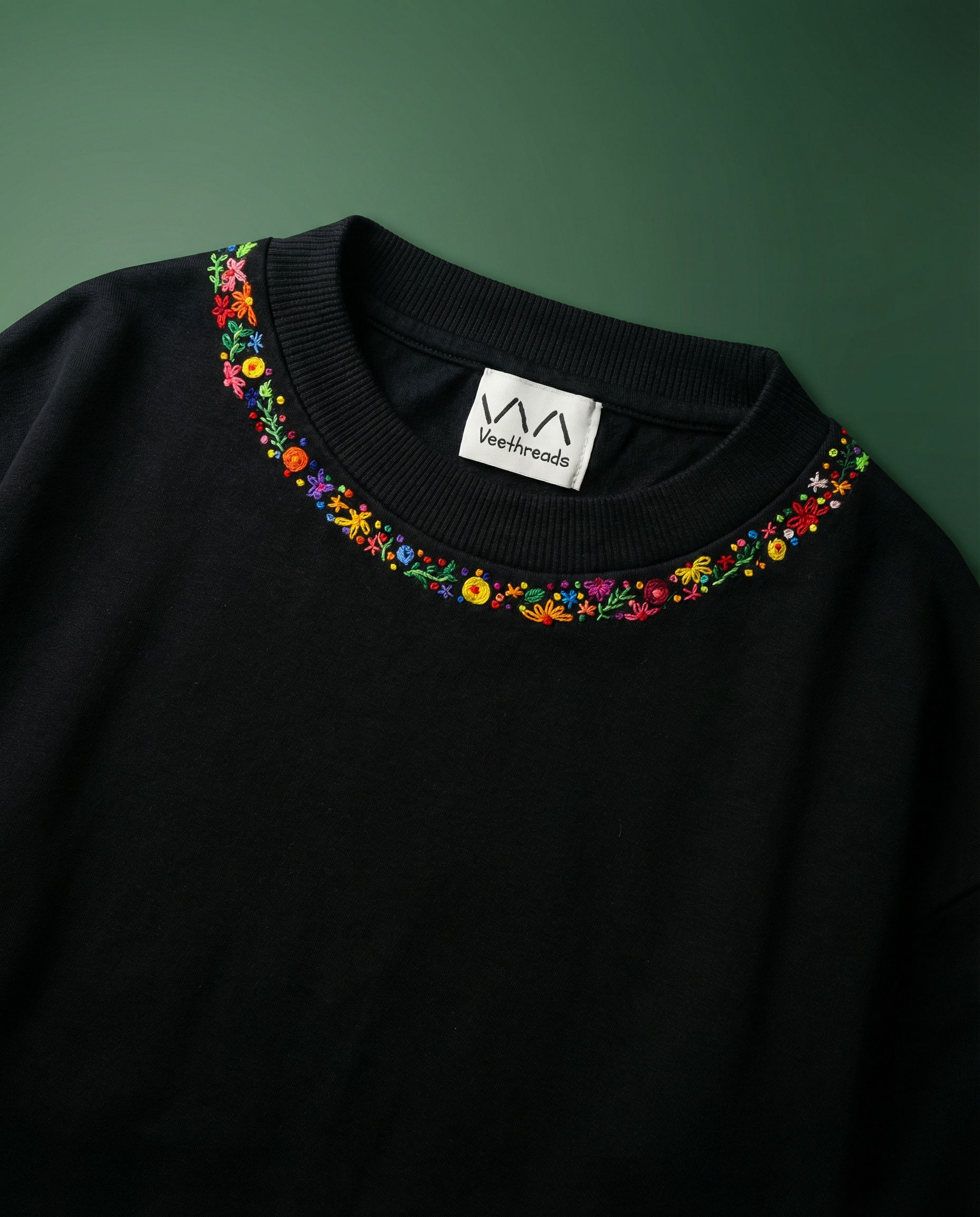 Embroidered flower shirt — hand-stitched floral blossom along neckline of white cotton tee, real thread artisan work