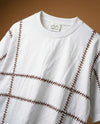Gridlock embroidered oversized t-shirt — white cotton tee with brown geometric hand-embroidered stitching pattern, oversized fit