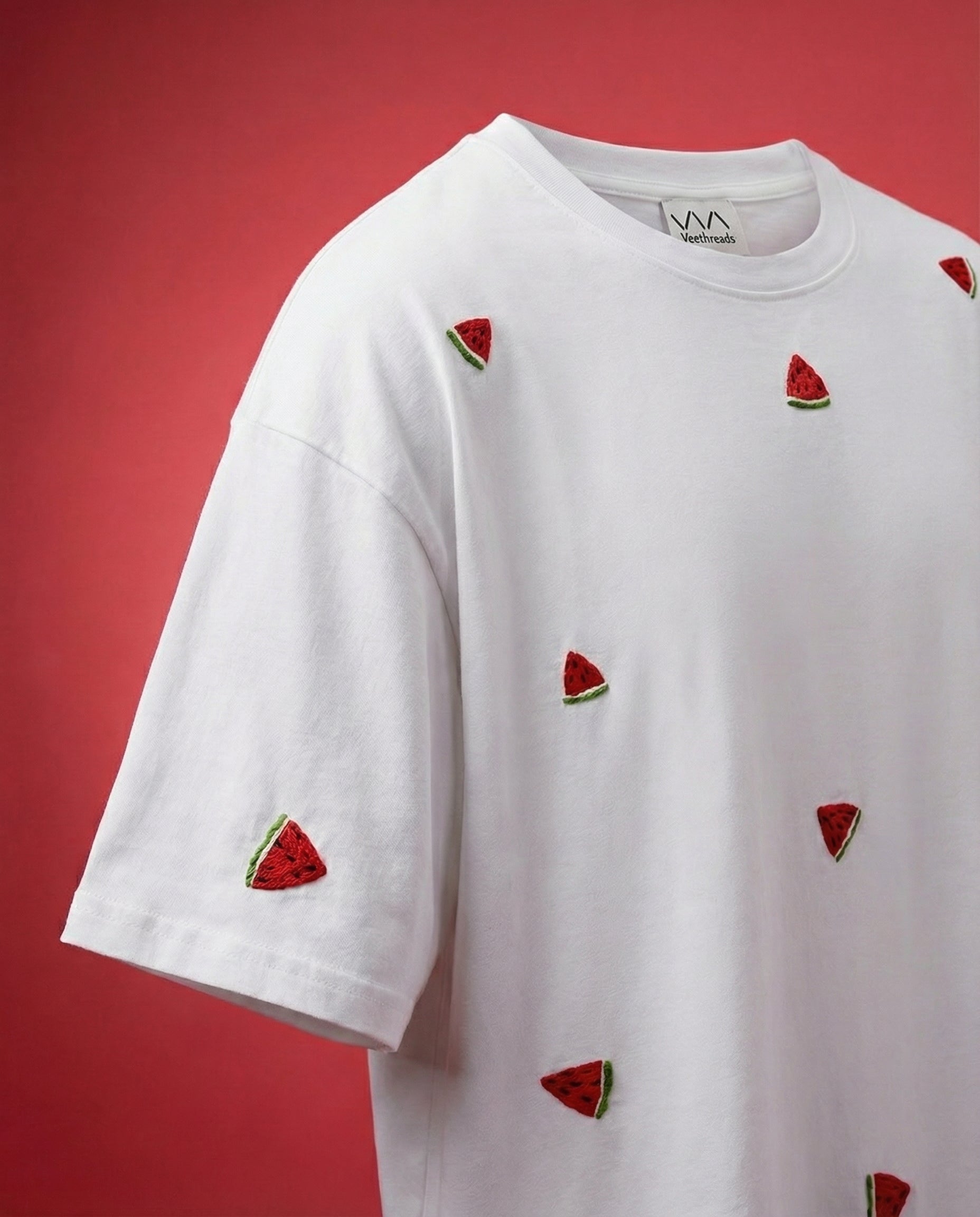 White t-shirt with embroidery  watermelon slice designs on a red background