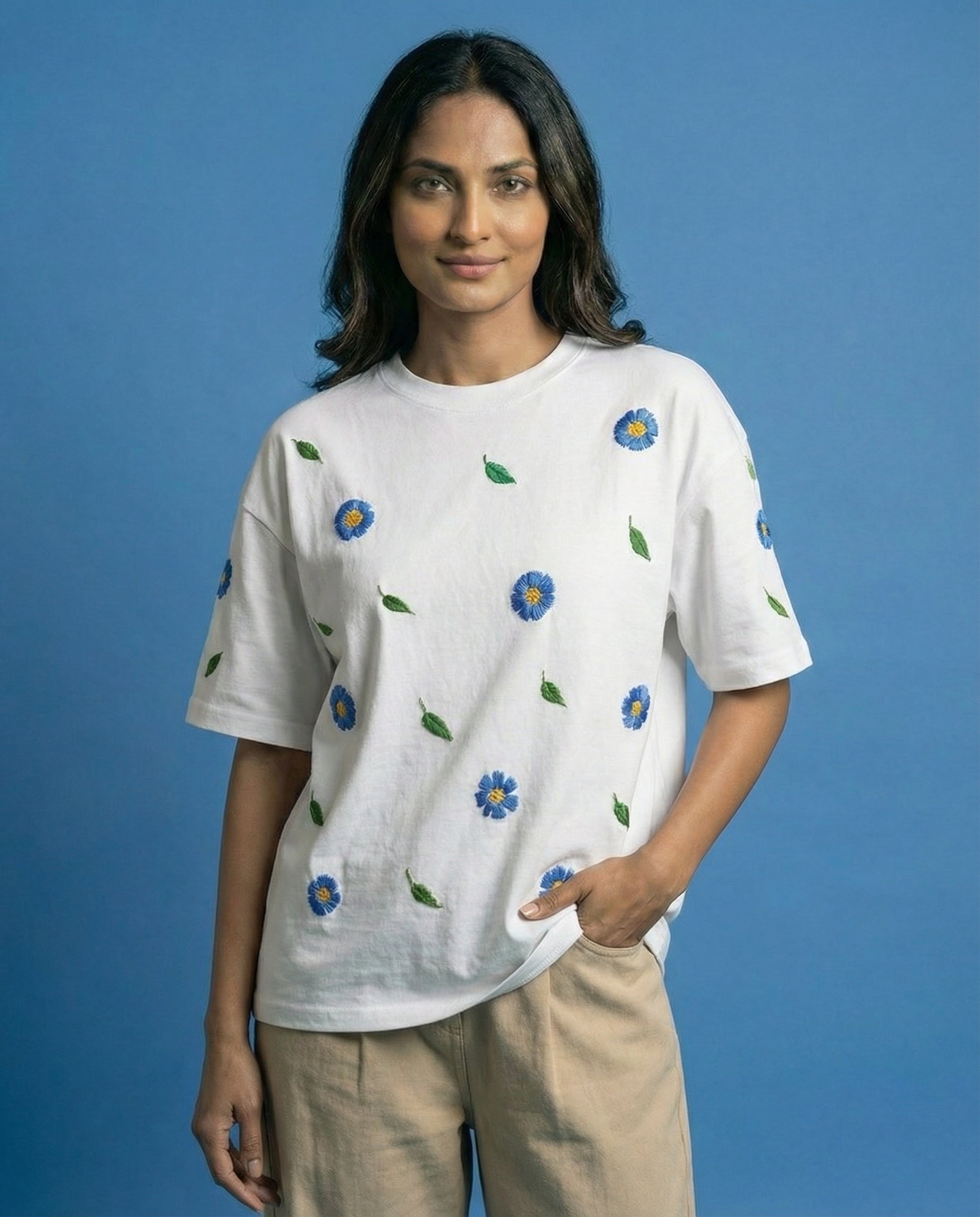 Woman wearing a white t-shirt with blue floral patterns on a blue background