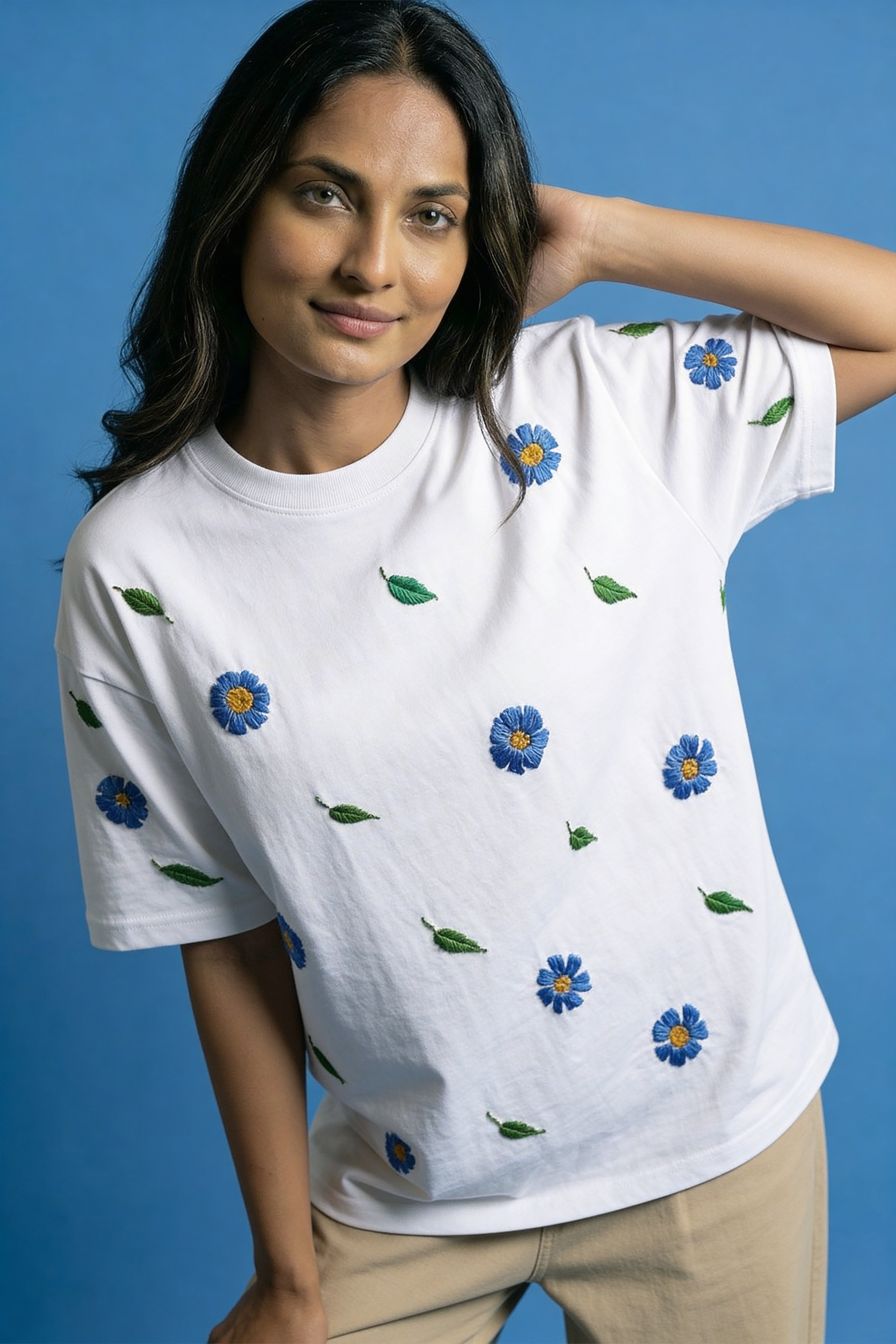 Woman wearing a white t-shirt with blue floral patterns on a blue background