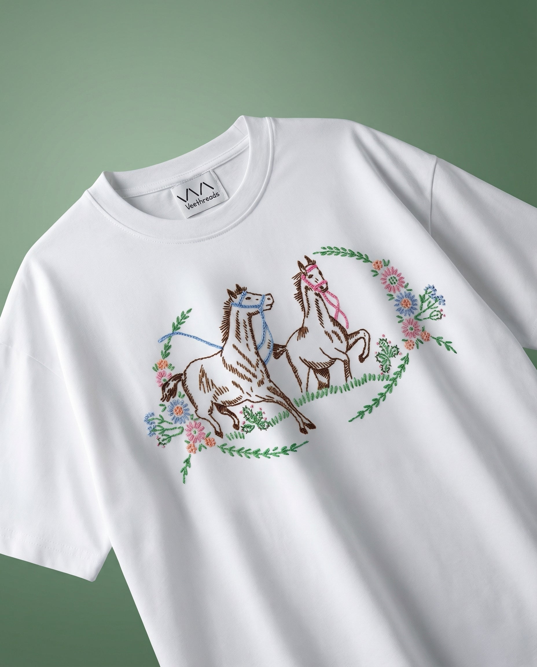 White t-shirt with horse embroidery design on a green background