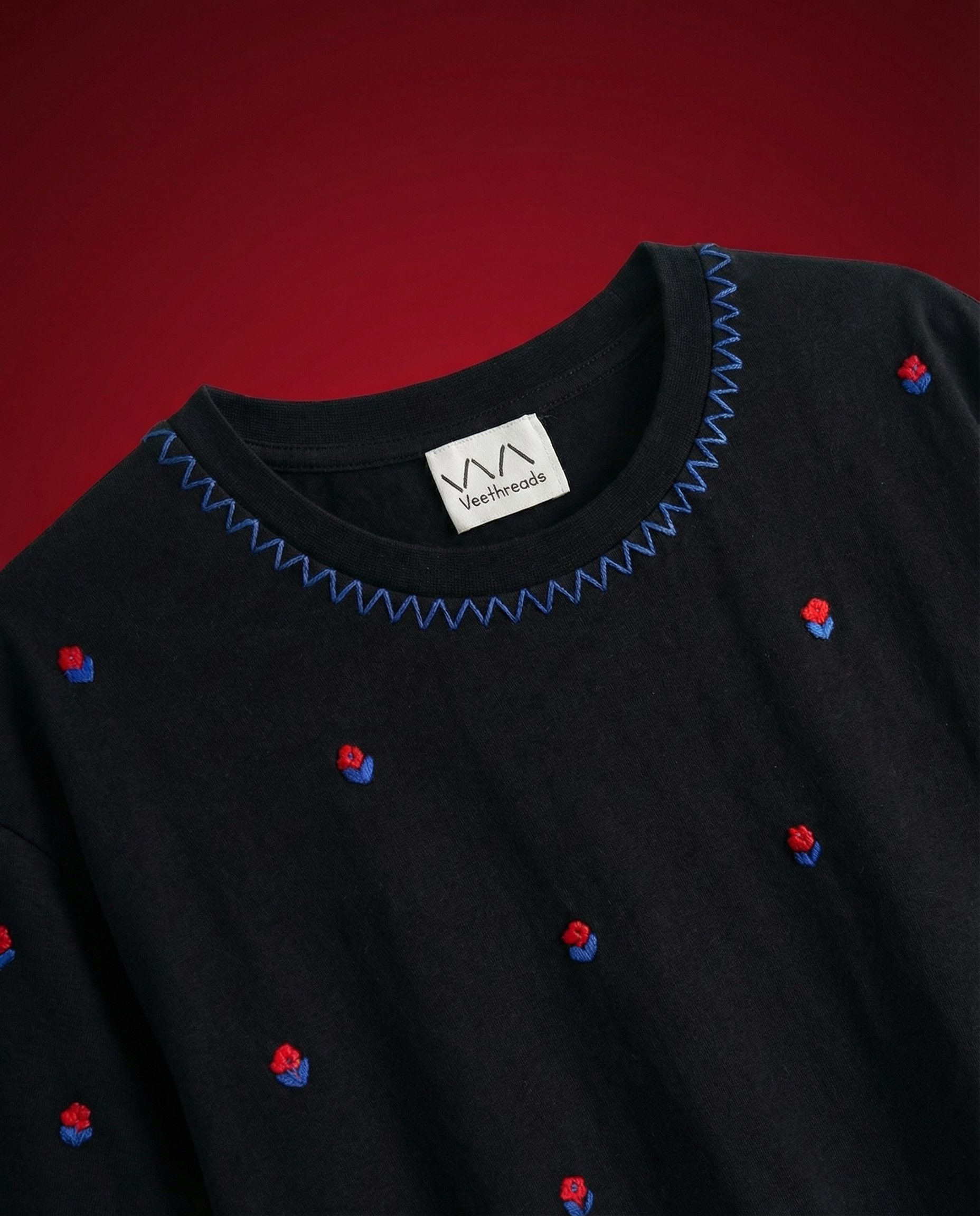 Hand embroidered floral t-shirt India — red rose bud all-over embroidery on black premium cotton tee by Veethreads