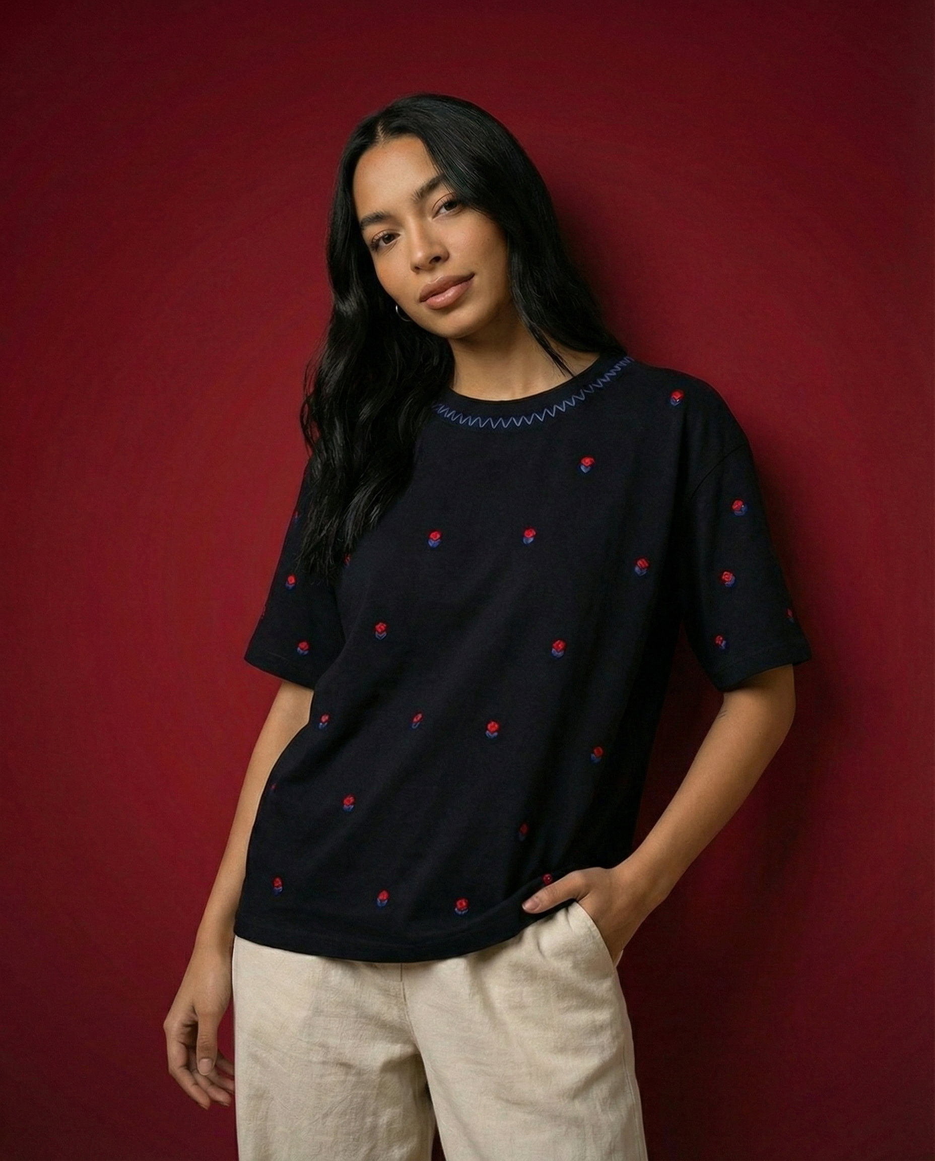 Woman wearing a black top with red polka dots against a red background
