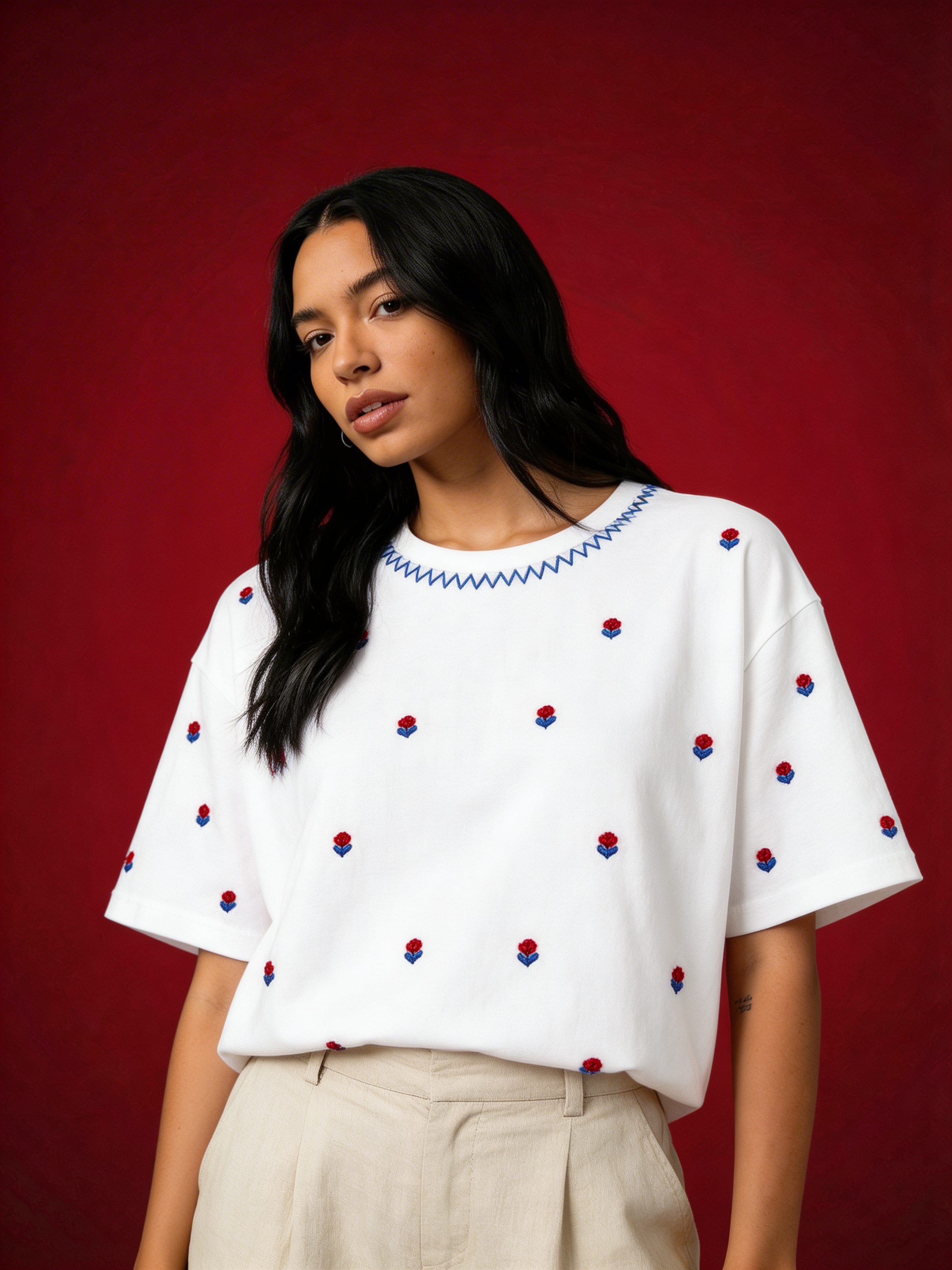 Woman wearing Cherry Blossom hand embroidered oversized white tee with red rose buds by Veethreads