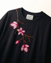 Cherry blossom hand embroidered black t-shirt — hand-embroidered pink cherry blossom branch with 3D satin stitch on navy blue cotton tee, close-up