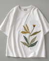 hand embroidered botanical bloom on The Botanist Tee by Veethreads — white cotton with mustard, olive and sage green stitching