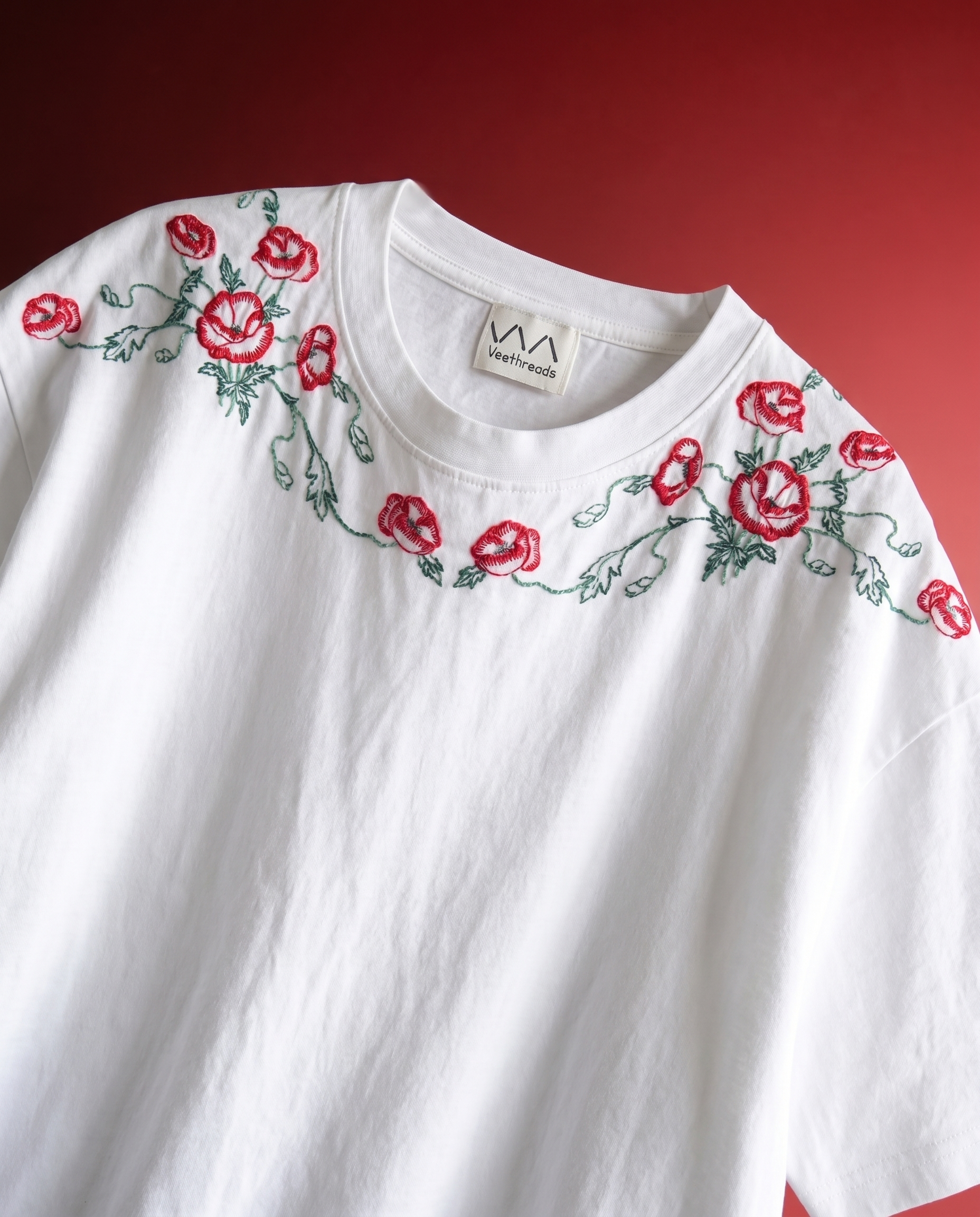 White shirt with red floral embroidery on a red background