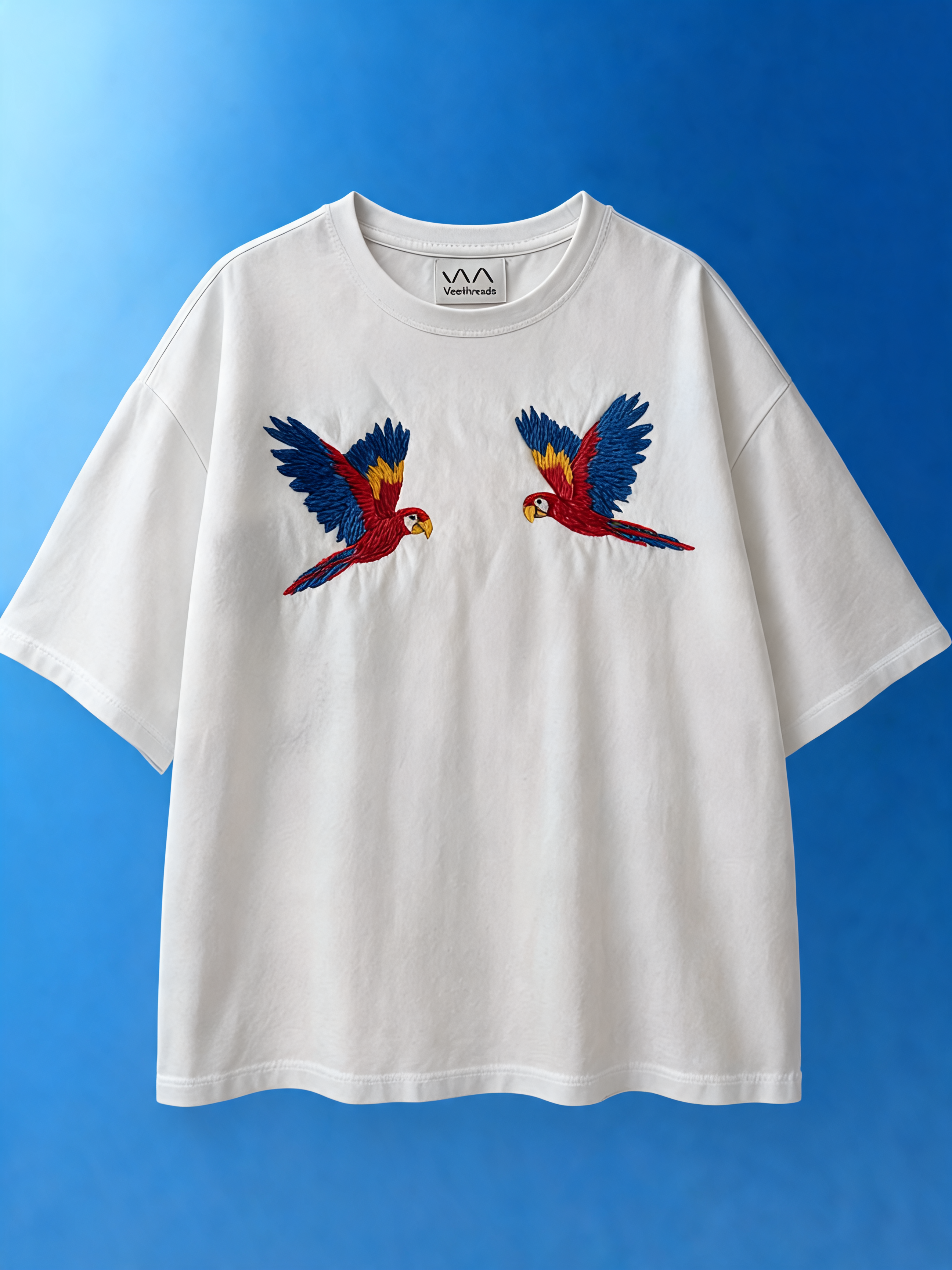 White t-shirt with parrot design on a blue background