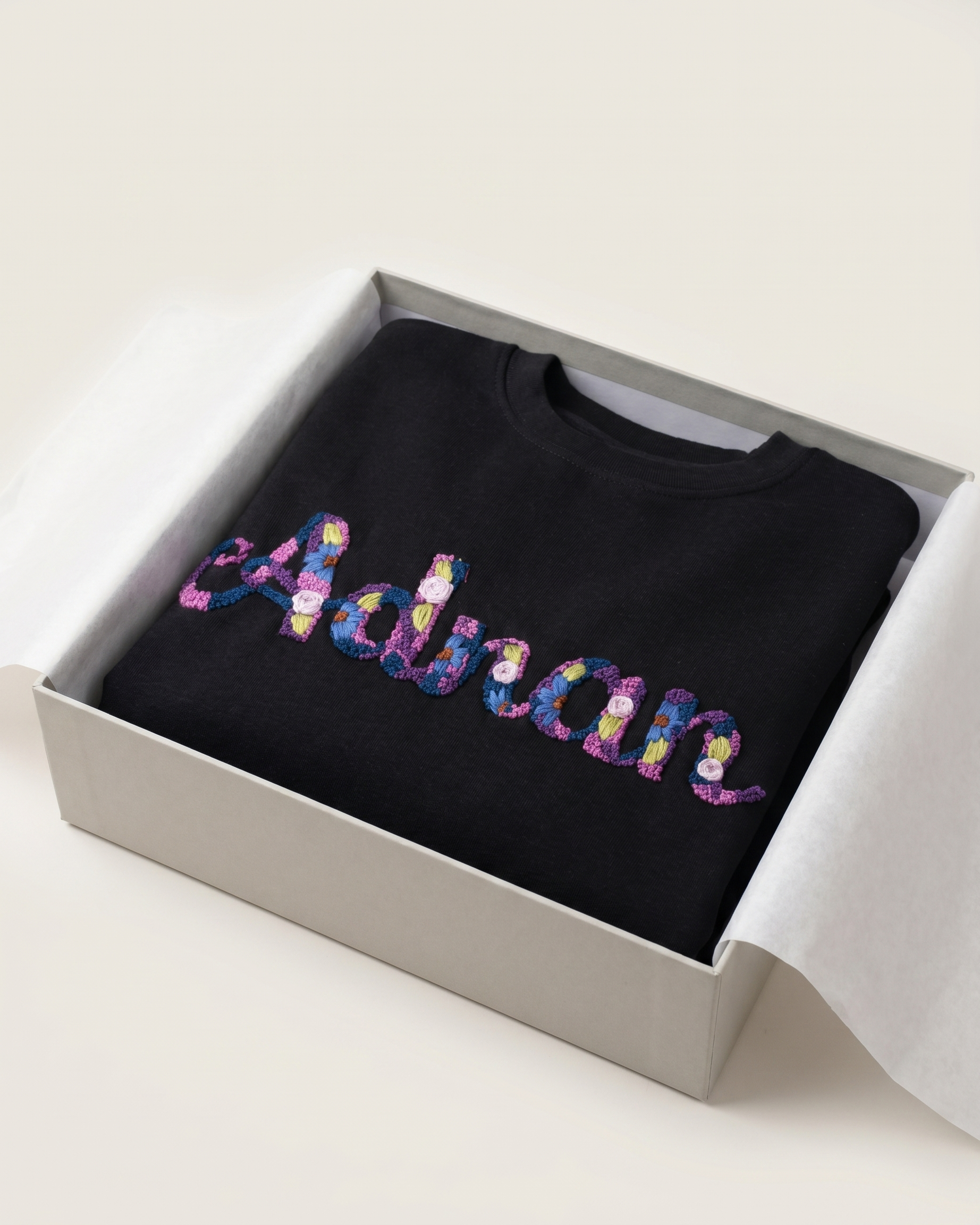 Black sweatshirt with colorful 'Adrian'  custom name text in a box on a white background