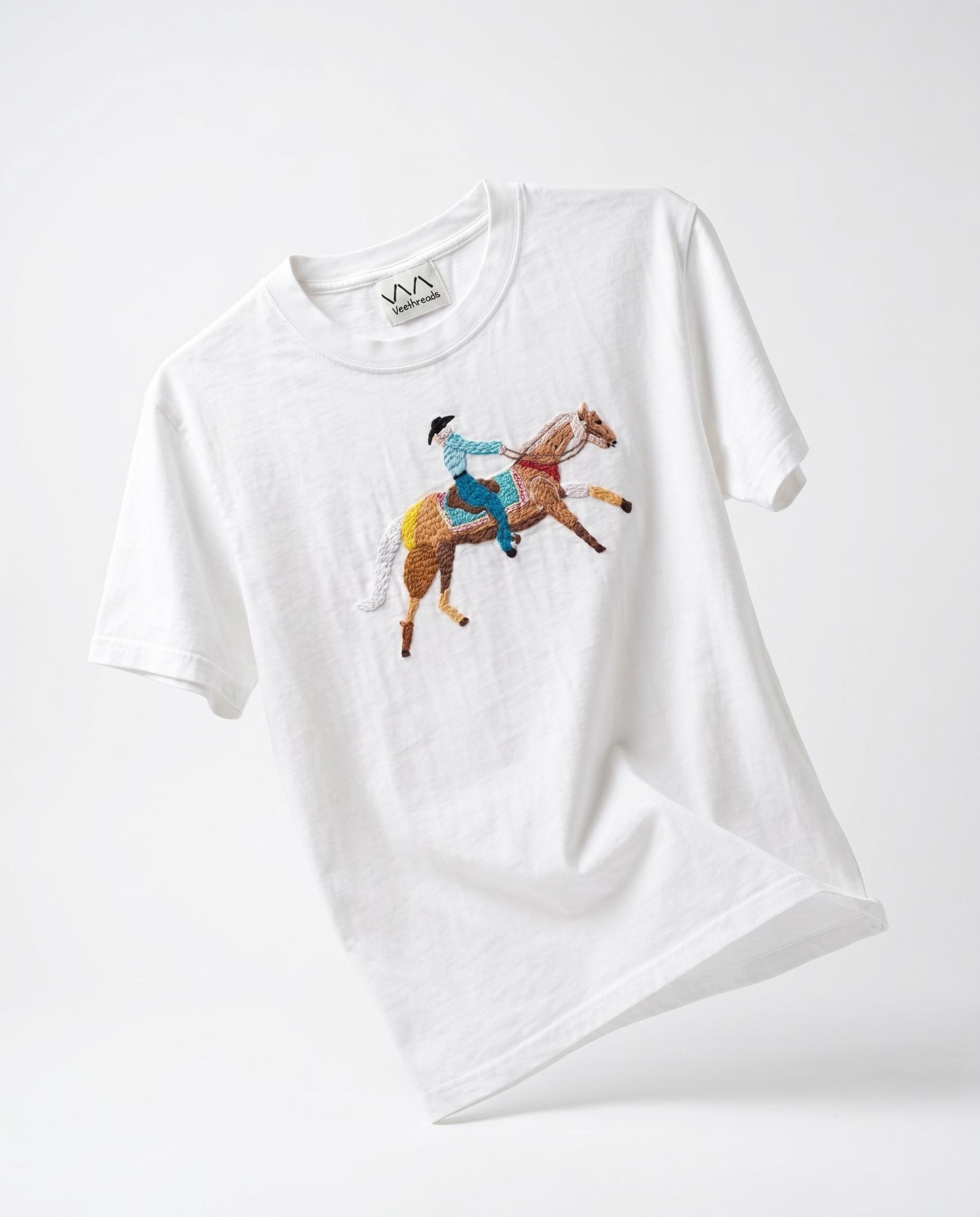 White cotton t-shirt with a hand-embroidered cowboy on a galloping palomino horse — Vee Threads