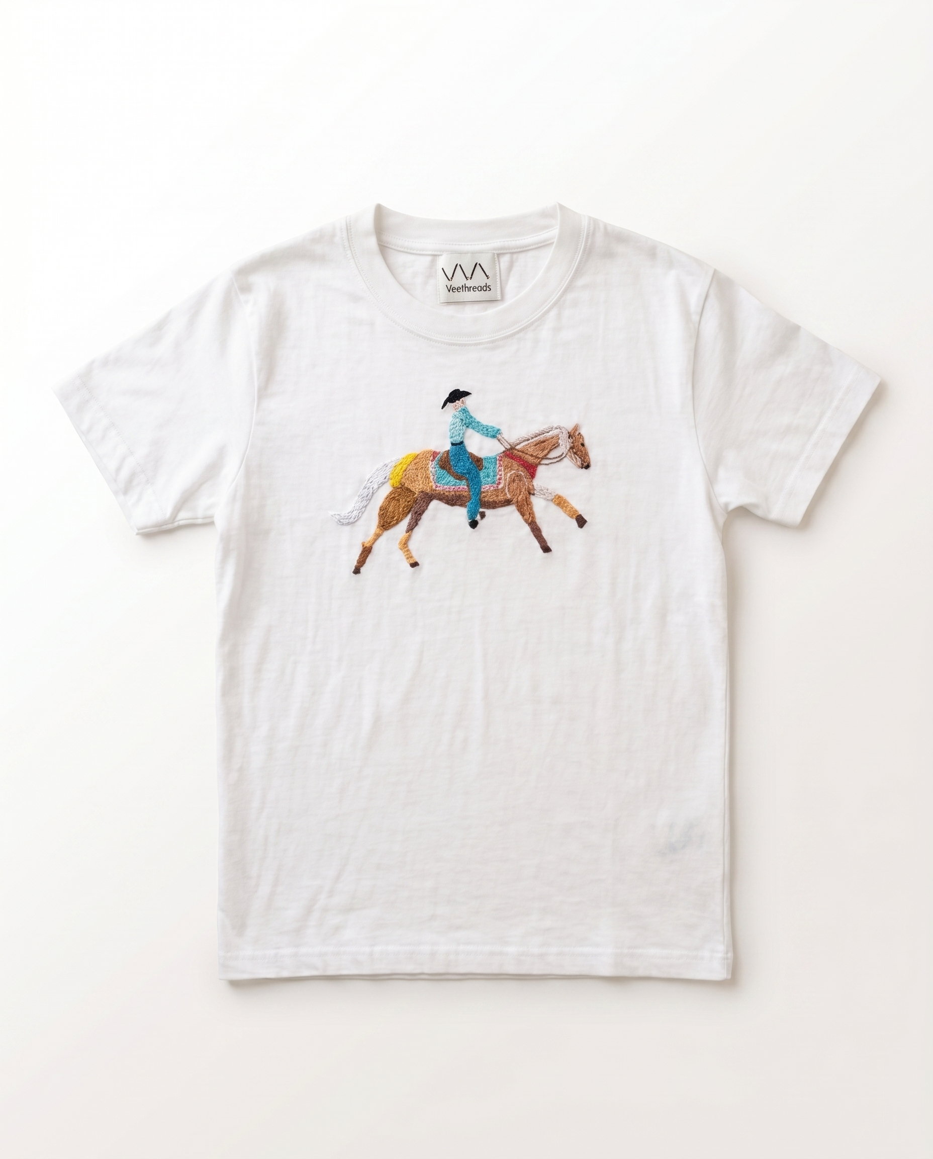 Hand-embroidered horse-and-rider scene in colourful cotton thread on a white t-shirt — Vee Threads