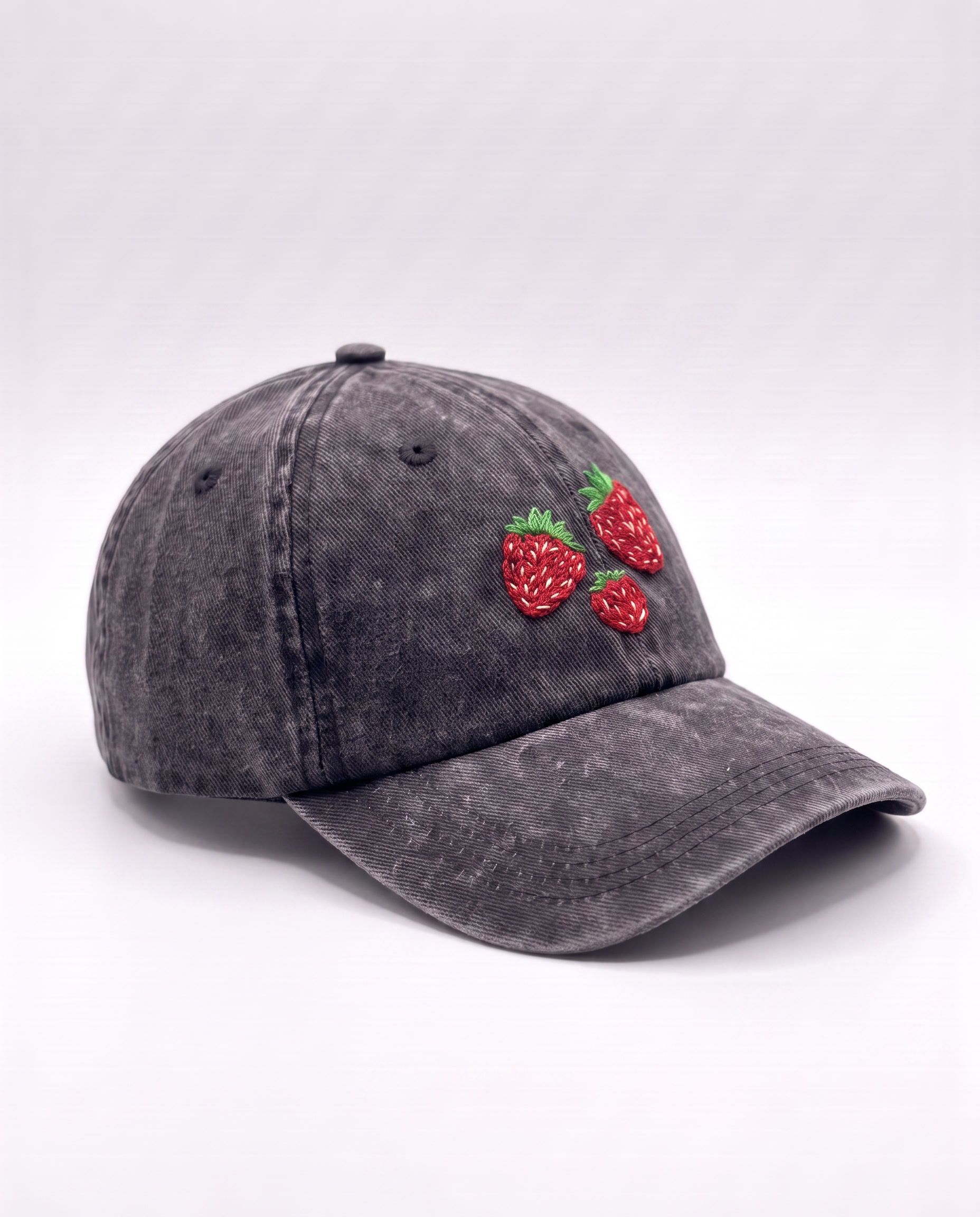 Side angle of the washed black strawberry cap showing the curved peak and faded charcoal wash