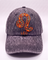 Leo zodiac cap, burnt orange lion glyph hand-embroidered in chain stitch on acid-wash denim