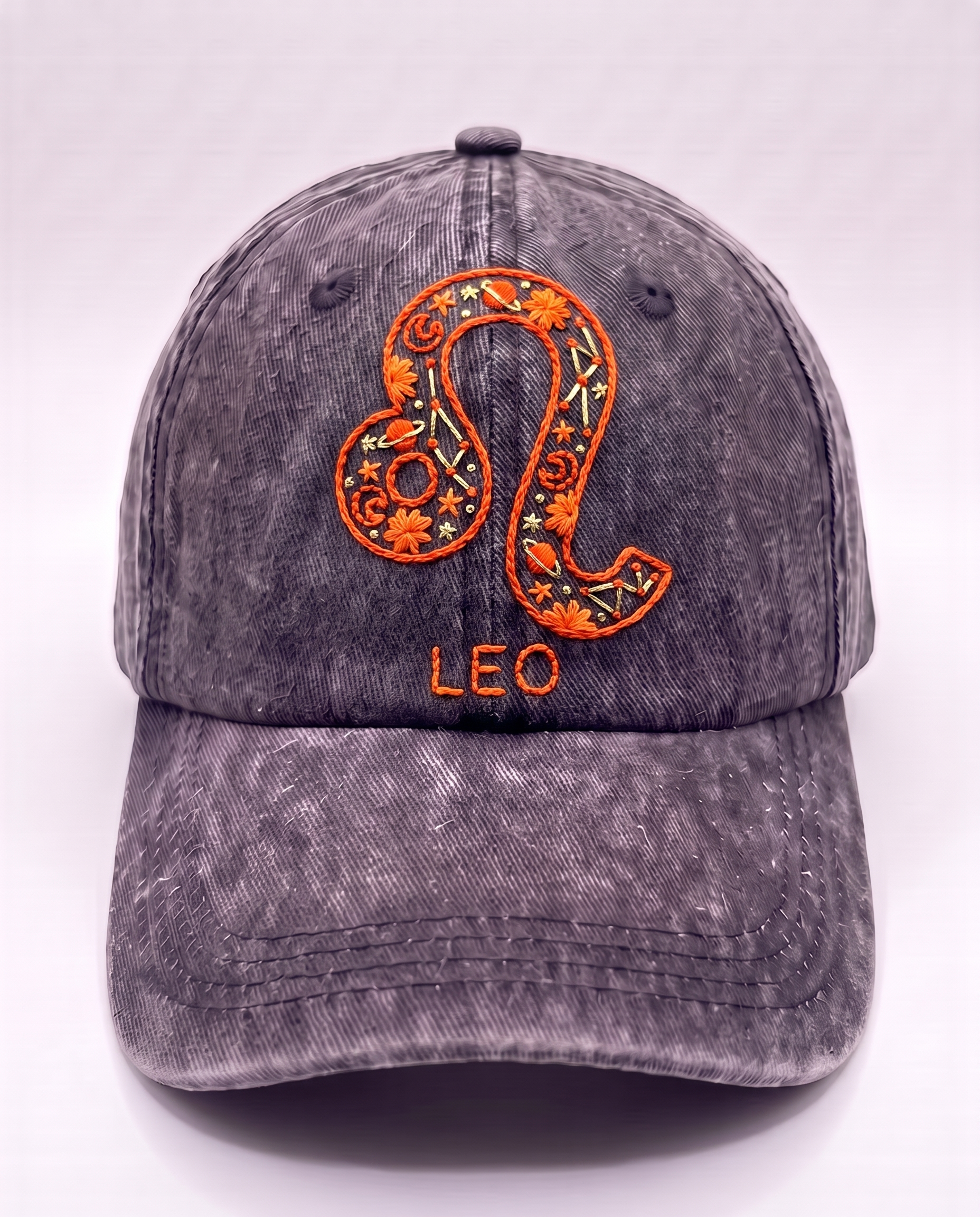 Leo zodiac cap, burnt orange lion glyph hand-embroidered in chain stitch on acid-wash denim