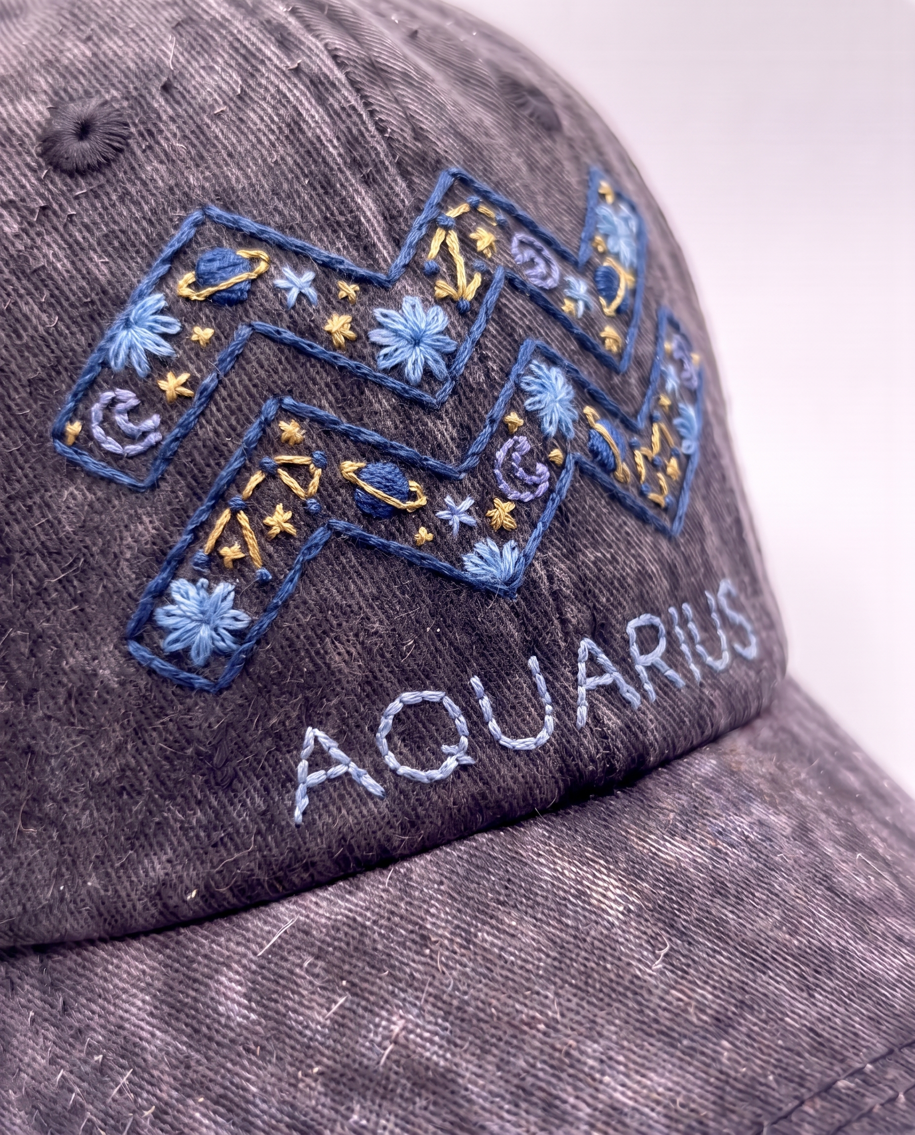 Aquarius zodiac embroidered cap by Vee Threads, navy and pale blue thread on washed denim