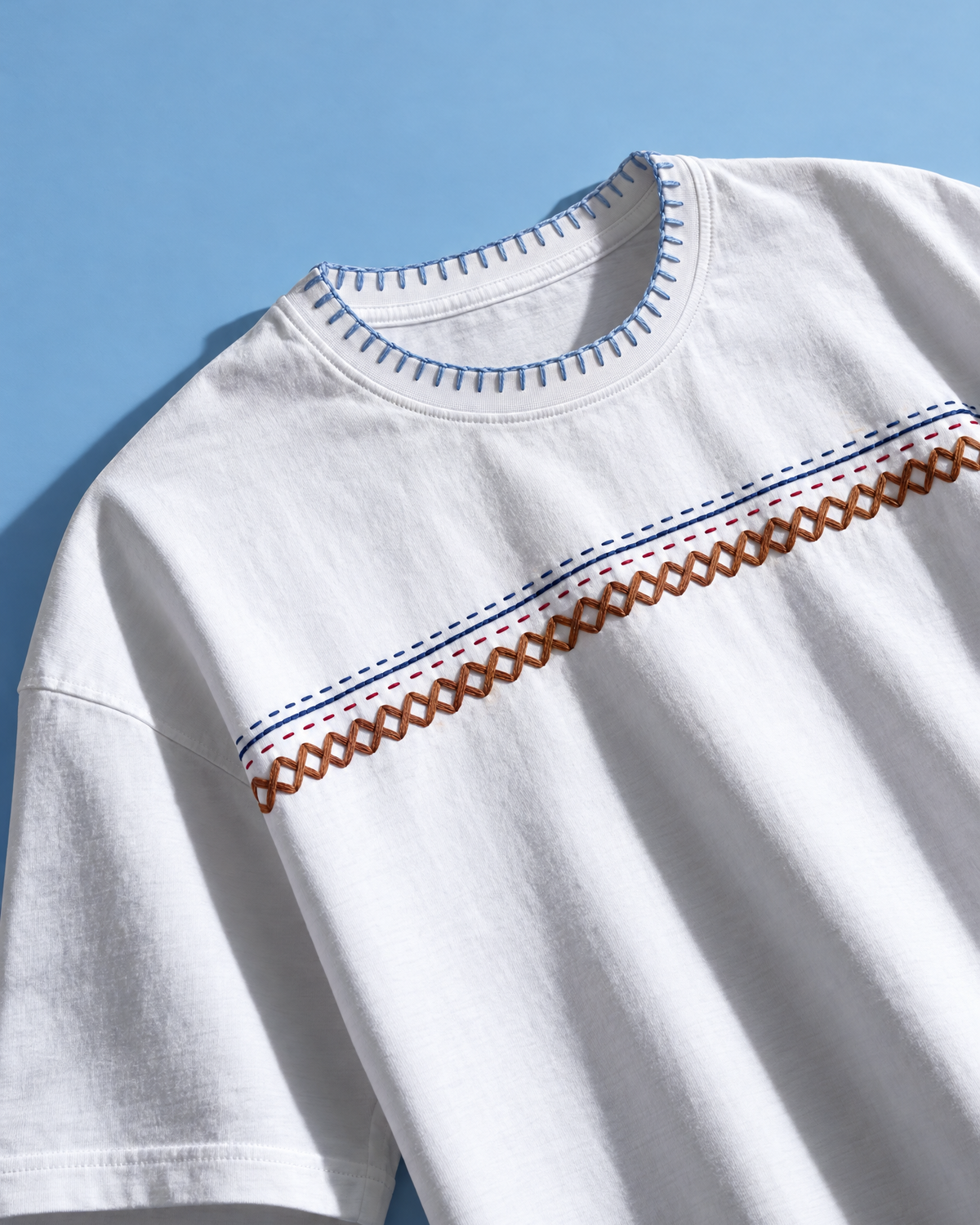 Angled view of the Taanka hand-embroidered white t-shirt showing the kantha chest band and stitched neckline
