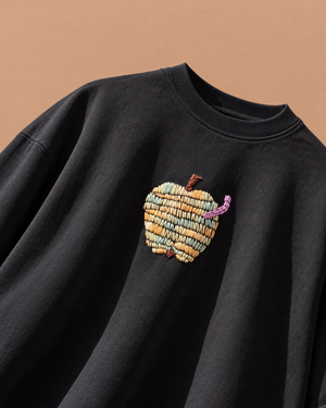 Apple hand-embroidered black oversized t-shirt with a small pastel apple and lilac worm on the chest