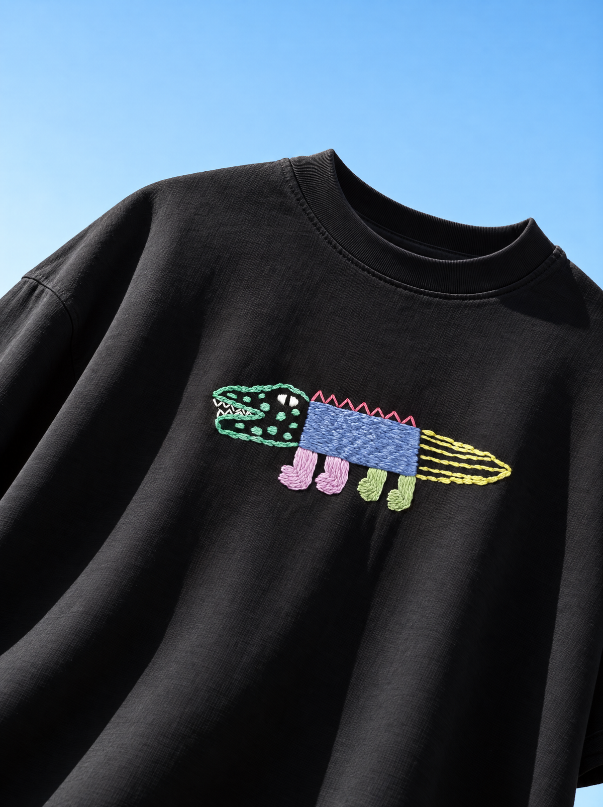 Crocodile hand-embroidered black oversized t-shirt with a green, blue and pink stitched crocodile across the chest