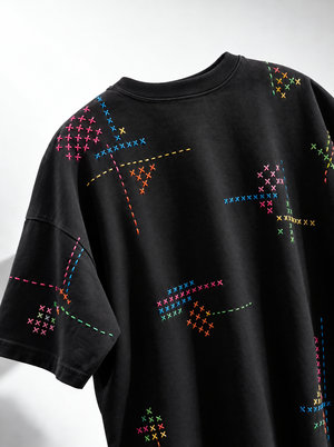 Cross stitch hand embroidered black oversized t-shirt with multicolour stitching across the front and sleeves